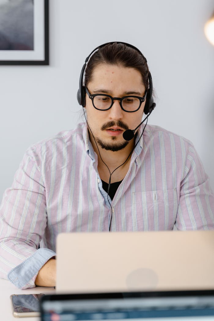Contact Professional customer support agent working remotely with headset and laptop, focusing on providing excellent service.